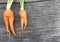 Orange Baby carrot look like woman shape on wooden background and space