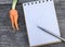 Orange Baby carrot on wooden background and space notebook and pen