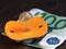 Orange baby pacifier and euro money