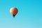 Orange balloon soars against the blue sky