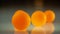Orange balls on a dark reflective surface