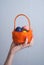 Orange basket with eggs in female hand, pink nail Polish,