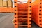 Orange big metal mobile shelving stacked in a warehouse of a construction shopping center. Placement and storage of goods