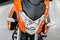 Orange bike, motorcycle, moped with lights. Front view. Front li