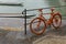 Orange bike at a river with barges