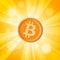 Orange bitcoin cryptocurrency in the bright yellow rays of sun