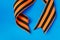 Orange black George ribbon on a blue background