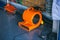 Orange blower fan machine on wet floor. Heavy Duty Industrial Portable Blower Fan on floor  Used to reduce heat to racing cars.