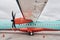 Orange and blue colored. Turboprop aircraft parked on the runway at daytime
