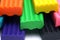 Orange, blue, green, yellow and black plastic clay sticks macro view