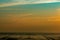 Orange and blue sunset sky and clouds. Sunset at the beach. Mud beach at seashore. Beautiful skyline at dusk. Landscape of muddy