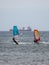 Orange and Blue windsurfing Riding the Waves in a Choppy Sea and Big Boat on Background