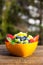 Orange bowl on wooden table, fresh seasonal fruits inside