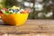 orange bowl on wooden table, strawberries, grapes and blueberries inside