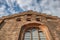 Orange brick facade of Aarhus Domkirke cathedral with a Gothic arched window reach for a cloudy sky conveys a religious concept