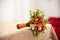 Orange bridal bouquet on a beige tablecloth