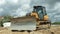 Orange bulldozer levels the sand on the construction site