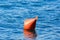 Orange buoy on blue water