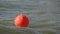 Orange buoy on sea waves