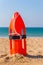 Orange buoy stands in beach sand