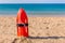 Orange buoy stands in sand on beach