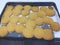 Orange butter cookies on a baking paper and wire rack. Biscuits made by children.Family time concept. Top view