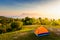 Orange camping tent at camping area in beautiful morning light.