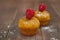 orange carrot cupcake with raspberry on wooden background, selective focus