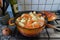 Orange casserole with meat, diced potatoes, carrots and celeriac on gas stove. Onion studded with cloves. Cooking scenery for