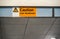 Orange ` Caution low headroom ` sign on roof above elevators