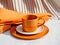 orange ceramic cup on on table with orange napkin