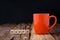 Orange ceramic empty mug and bamboo letter box arranged words ha