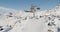 Orange chair lift ride at Samnaun Ischgl ski resort, above rocky terrain covered with snow on the border of Austria, Switzerland.