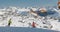 Orange chairlift and unrecognizable skiers on the border of Austria and Switzerland, between the villages of Ischgl and Samnaun.