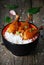 Orange chicken thighs with white rice in bowl