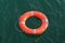 Orange circle lifebuoy floating on water