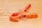 Orange clothespin on wood background