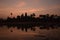 Orange cloud sunrise over famous angkor wat temple with lake and reflection in the water with lillypad