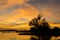 Orange clouds streak the sky over the lake at sunset