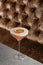 Orange Clover Club Cocktail in Coupe Glass with Layer of Foam and orange chips Garnish isolated on dark Background.
