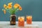 Orange cocktail in vintage crystal glasses with marigold flower bouquet in retro style dark brown glass bottle. Colorful