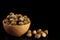 Orange color bowl with hazelnuts and hazelnuts on table