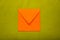 Orange color envelope on green background, as symbol of getting mail, advertisement element.