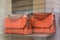 Orange color leather handbags by Lancel in a luxury fashion store showroom