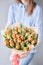 Orange color tulips in woman hand. Young beautiful woman holding a spring bouquet. Bunch of fresh cut spring flowers in