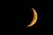 Orange colored waxing crescent moon