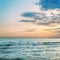 Orange colors clouds over sea with waves in sunset