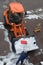 Orange-coloured Snowplough on the Road and Snowman filling the Tractor with Snow