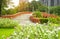 Orange concrete arch curve brige and lake in a beautiful garden, fresh pink and white West Indian perwinkle petals