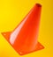 Orange cone, road barrier isolated on a yellow background